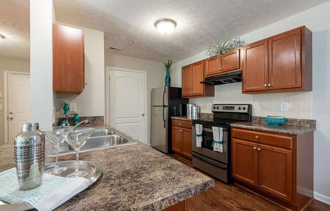 A kitchen with brown cabinets and a granite countertop.