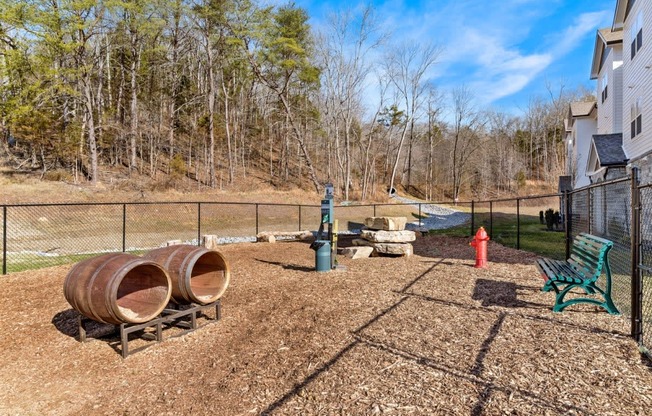 Ashland Farms Community Fenced-In Bark Park with Seating, Play Barrels, and Shade.