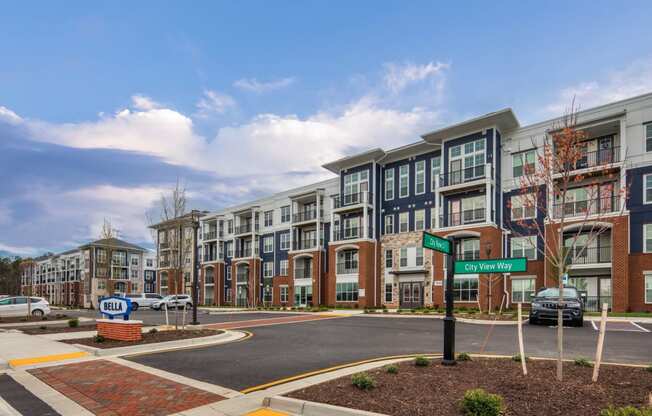 an exterior view of an apartment building on a city street at The Bella at Westchester, Virginia
