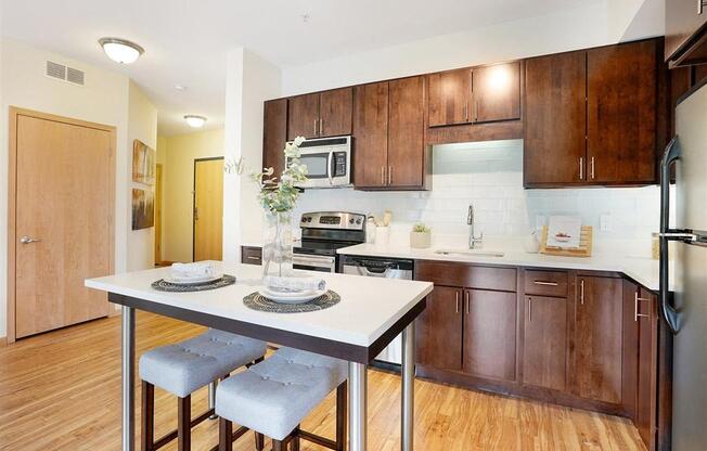 A kitchen with a table and chairs in front of it.