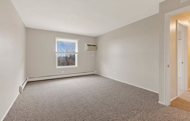 an empty room with carpet and a window