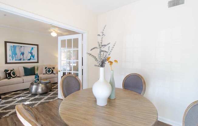 A dining table with a vase and a plant on it.