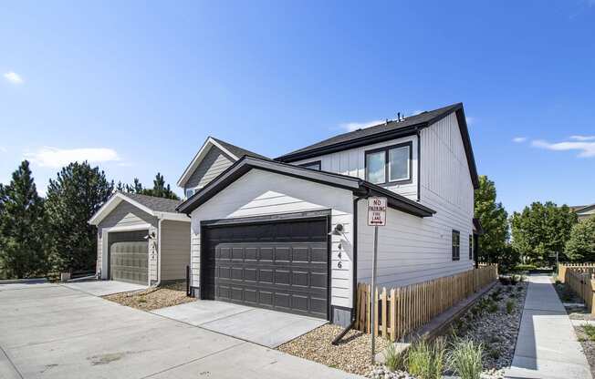 a white house with a garage door and a sidewalk