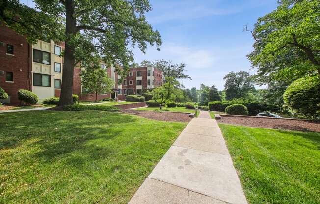 a grassy area with trees and buildings in the background