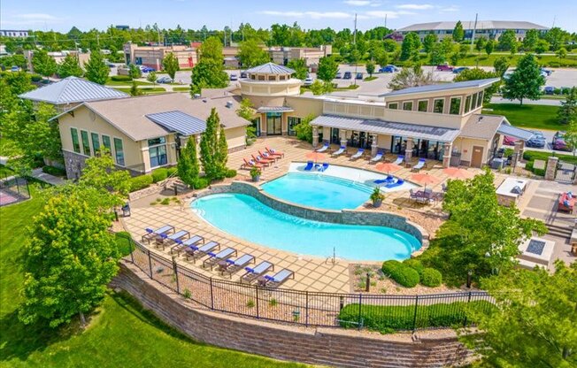 an aerial view of a resort style pool with lounge chairs