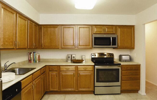 Kitchen with Cabinets and stainless steel appliances at Town & Country Luxury Apartments, Hampton Bays, NY