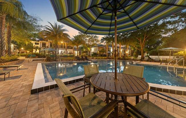 Community Swimming Pool with Pool Furniture at Grand Pavilion Apartments in Tampa, FL.