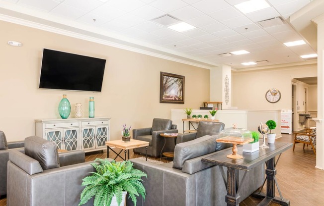 a living room with leather chairs and a television