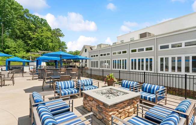 a patio with blue and white chairs and tables and a fire pit at The Tannery, Connecticut, 06033