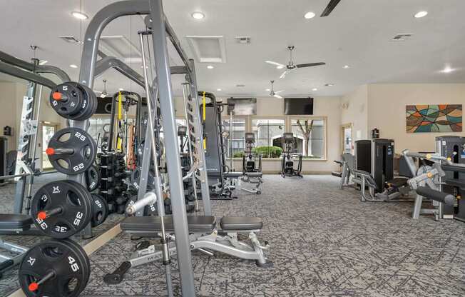 A gym with a variety of equipment including weights and machines.