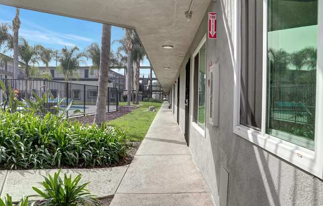 A long concrete walkway with a red sign on the wall.