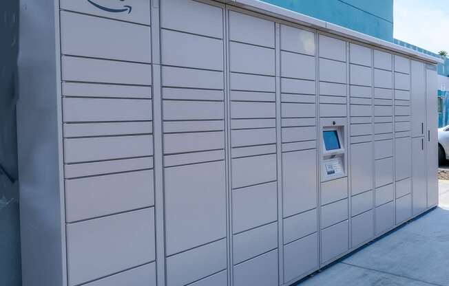 Fifteen 50 apartments Las Vegas amazon hub with screen and keypad in center in front of blue wooden plank wall