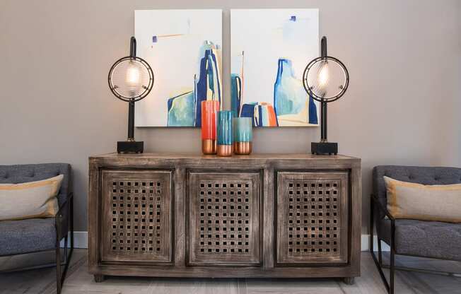 a room with a table and two chairs and two paintings on the wall