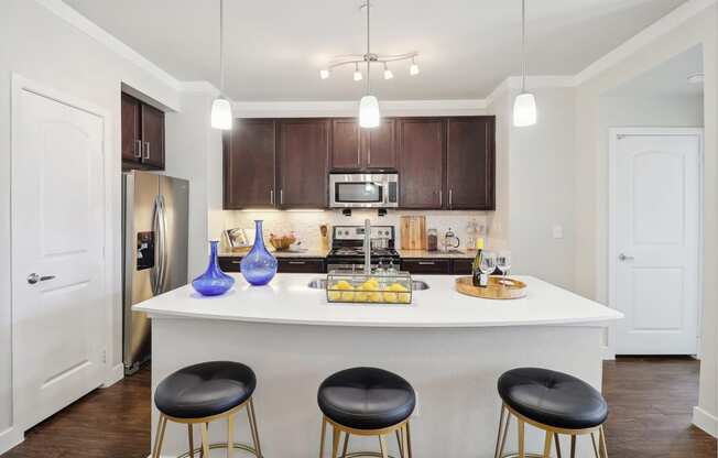 a kitchen with a large island with three stools