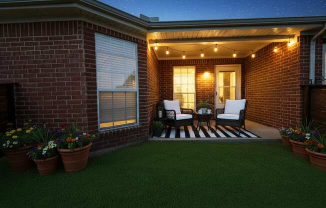 A cozy outdoor space with a brick wall and a striped rug.