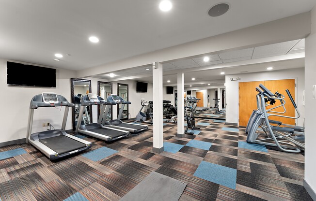 A gym with treadmills, exercise bikes and other equipment.