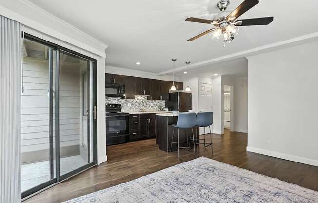A modern kitchen with a dining area and a ceiling fan.