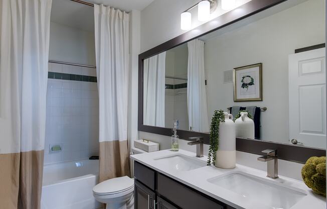 a bathroom with a large mirror and a toilet next to a bathtub