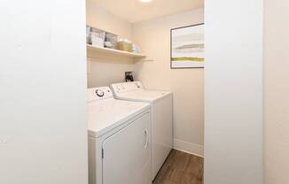 A small laundry room with a washer and dryer.