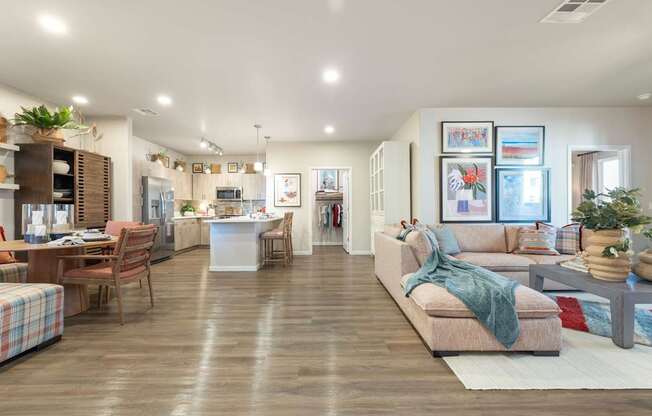 A spacious living room with a couch, chairs, and a dining table.