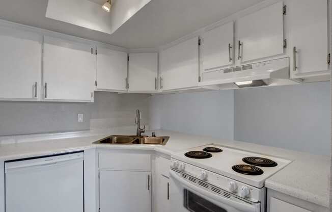 a kitchen with white cabinets and white appliances and a sink