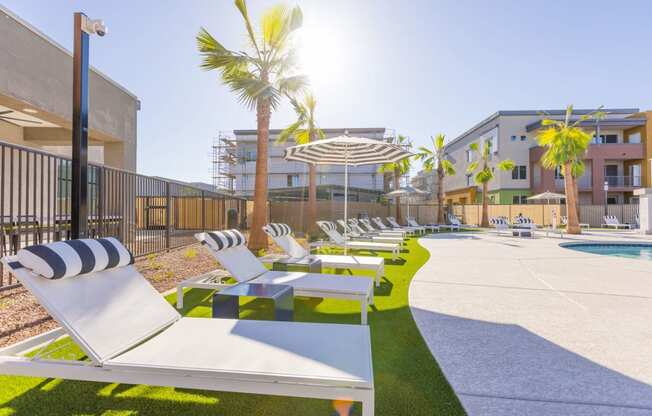 a row of lounge chairs next to a pool in a building