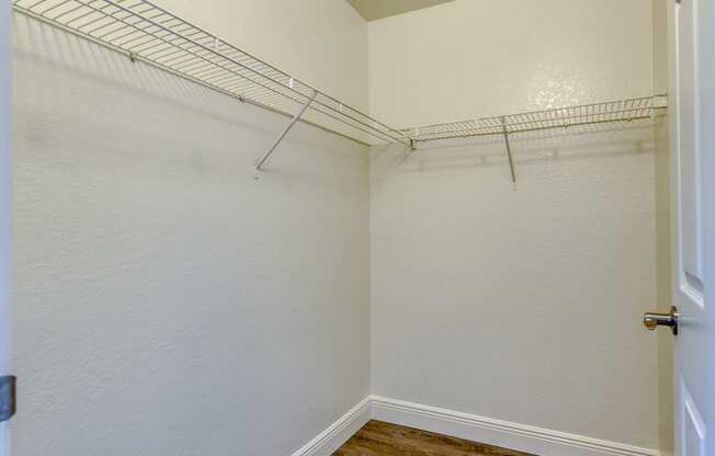 an empty closet with a wire rack on the wall