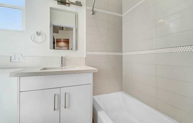 a bathroom with a tub and a sink and a mirror