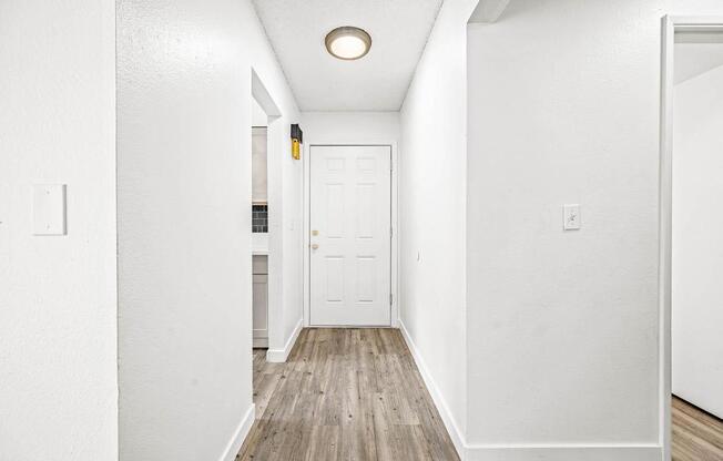 a hallway with a white door and white walls