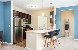 a kitchen with a island and a stainless steel refrigerator