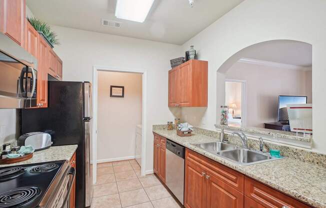 A kitchen with a black stove top oven and wooden cabinets.