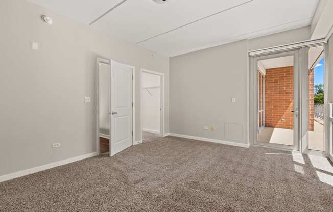 a living room with a carpeted floor and a door to a balcony