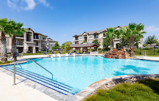 a large swimming pool with an apartment building in the background