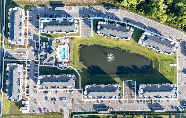 An aerial view of a large complex with a lake in the middle.