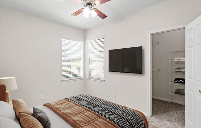 a bedroom with a large bed and a ceiling fan