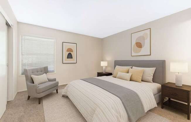 A bedroom with a bed, chair, and two lamps.