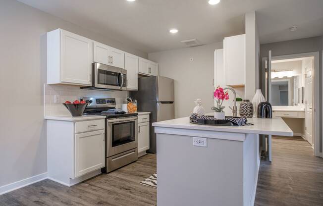 a kitchen with white cabinets and stainless steel appliances at Saw Mill Village apartments