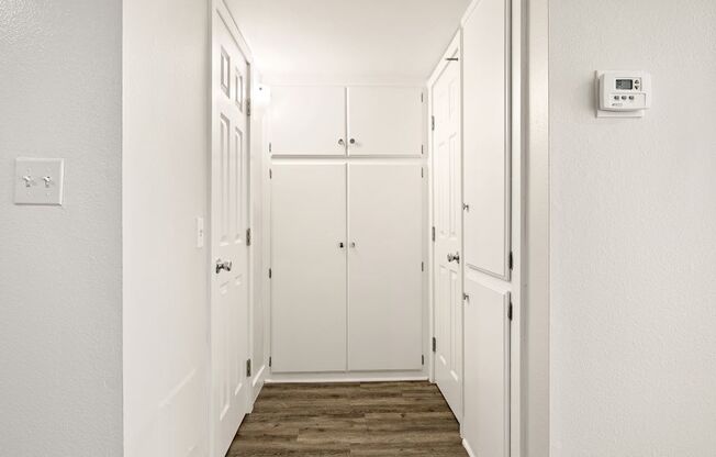 A hallway with a thermostat on the wall.