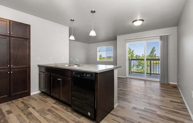 A kitchen with a black dishwasher and wooden cabinets.