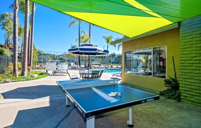 A ping pong table is in the middle of a patio.