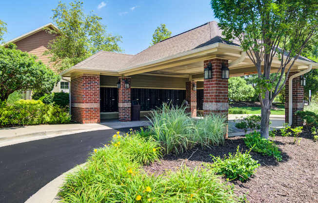A house with a red brick chimney and a brown roof with a landscaped front yard.