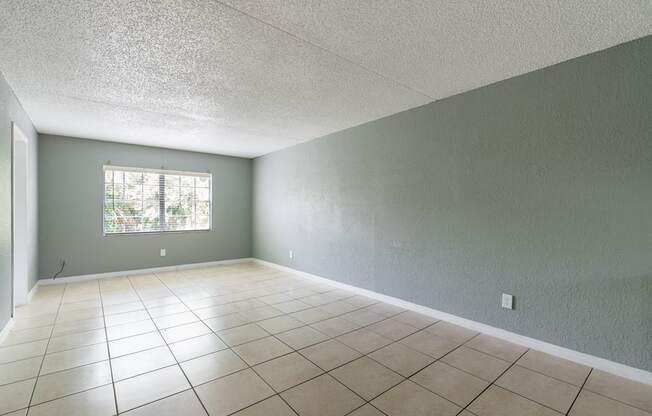 an empty room with a large tiled floor at Bella Mar Apartments