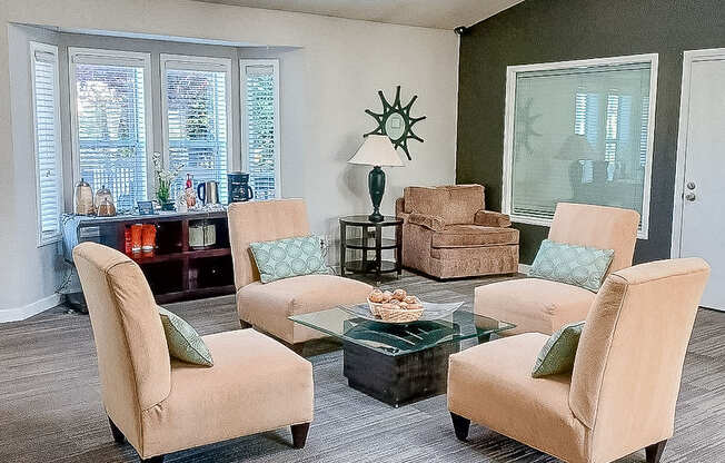 A living room with a glass table and four chairs.