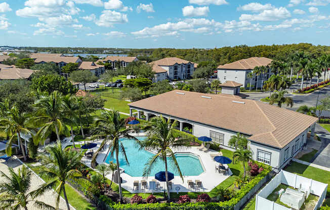 A large white building with a pool in front of it.