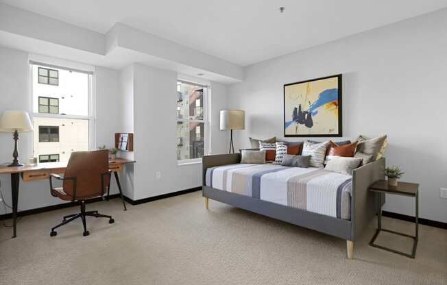 a bedroom with a bed and a desk with a chair