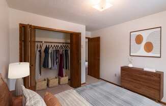 a bedroom with a closet and a bed and a dresser. Fargo, ND Huntington Apartments