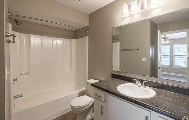 A bathroom with a toilet, sink, and bathtub.