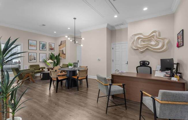 A well-lit office space with a desk, chairs, and a potted plant.