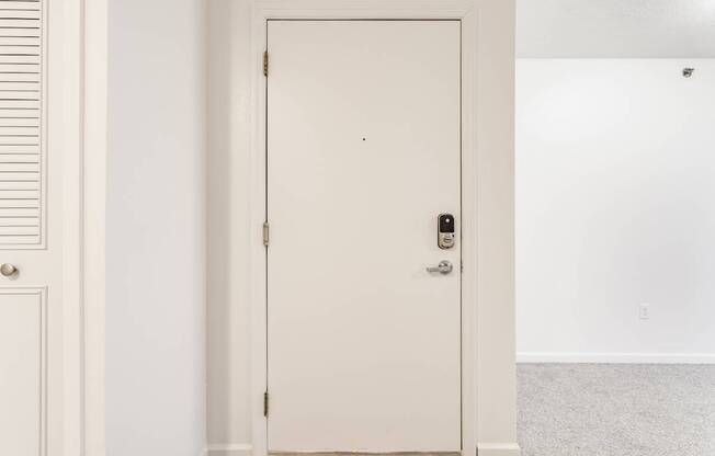 A white door with a black handle and a lock.