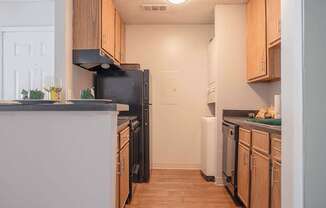 a kitchen with wooden cabinets and a black refrigerator